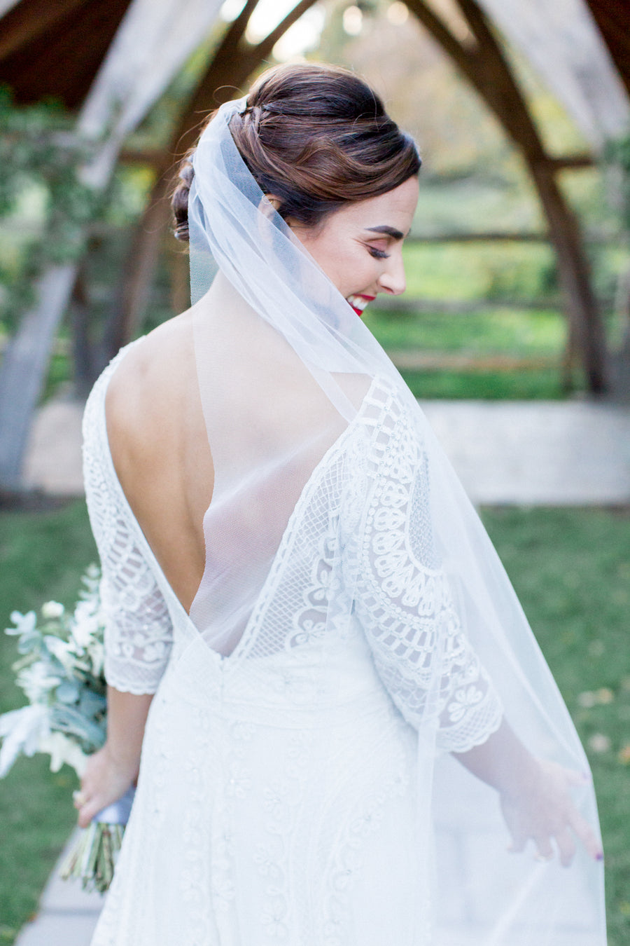 Georgina from behind, the lace back of her Temperley London gown showing through a sheer Skylar veil