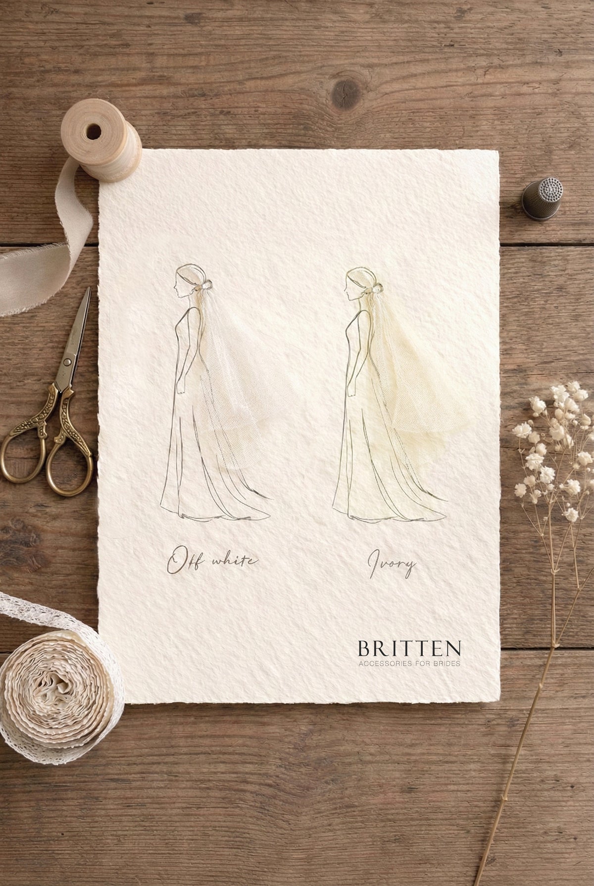 Flat lay color comparison guide for wedding veils on textured paper. Two side-by-side sketches illustrate the difference between "Off white" and "Ivory" tulle, with the ivory showing a warmer, creamier tone. The chart is styled on a rustic wooden background with vintage scissors, lace ribbon, a thimble, and dried flowers.