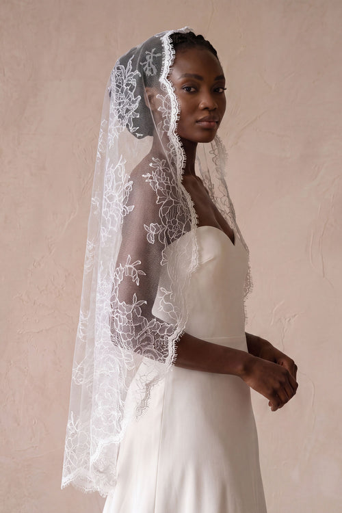 All-over floral lace mantilla bridal veil draped elegantly over a bride's head and shoulders