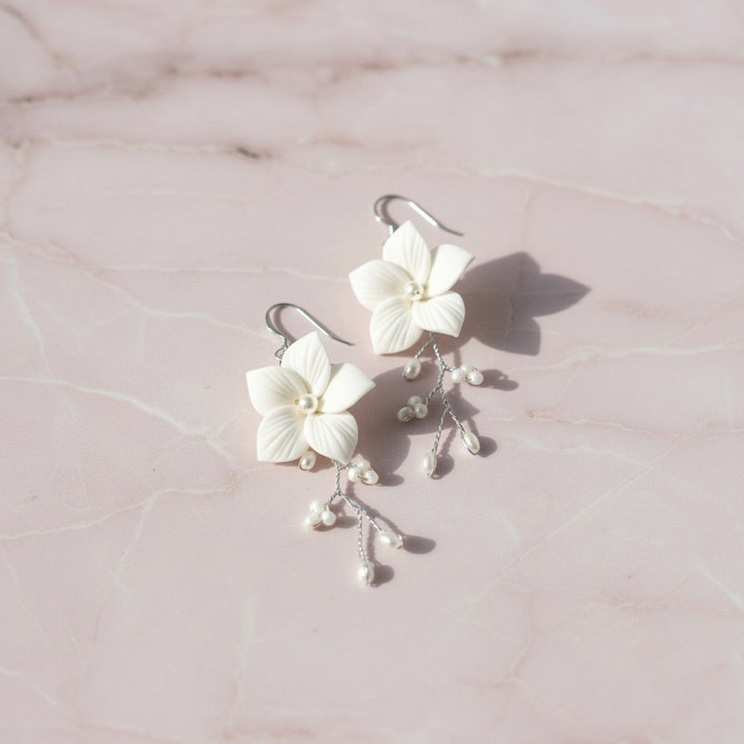Handcrafted white floral and pearl bridal earrings — Hazel design by Britten Weddings.