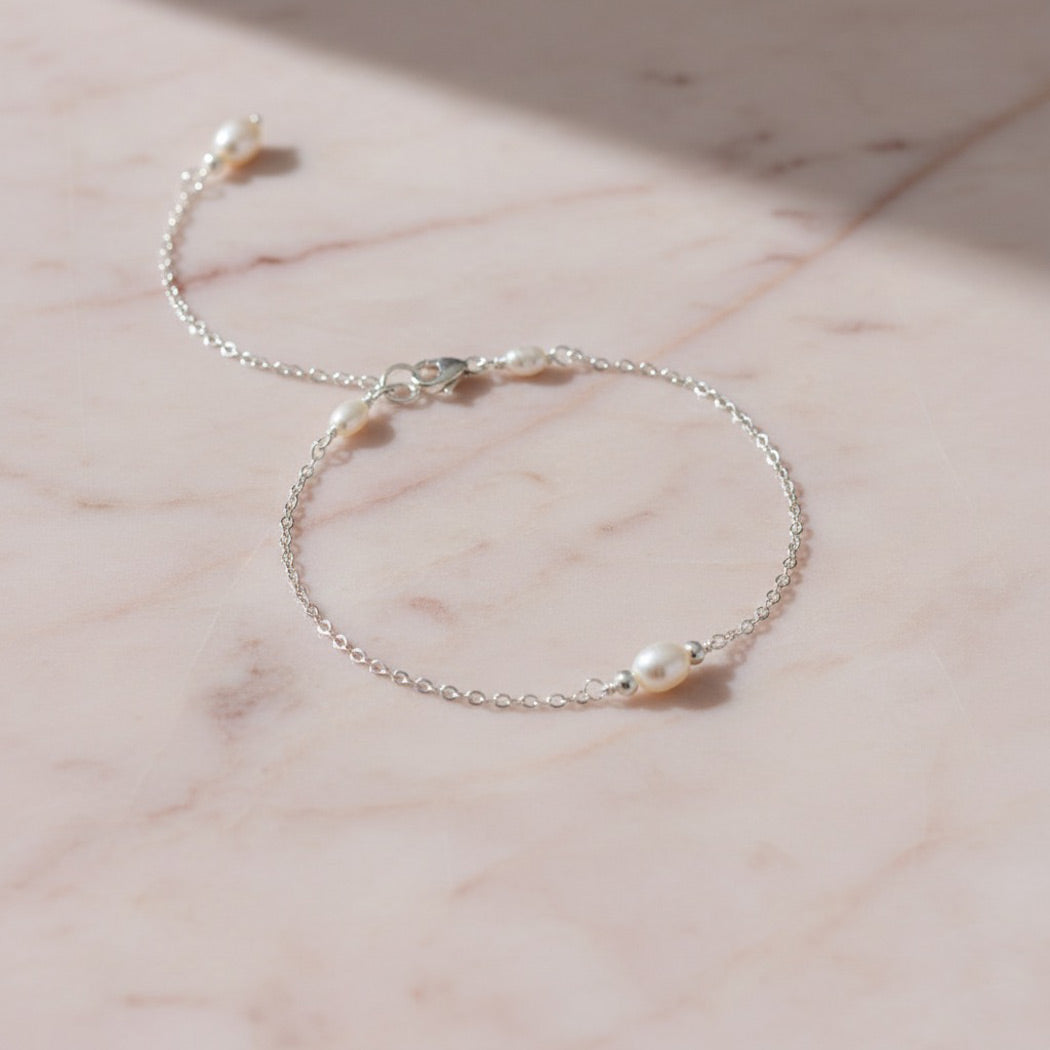 Dainty silver bracelet featuring small freshwater pearls.