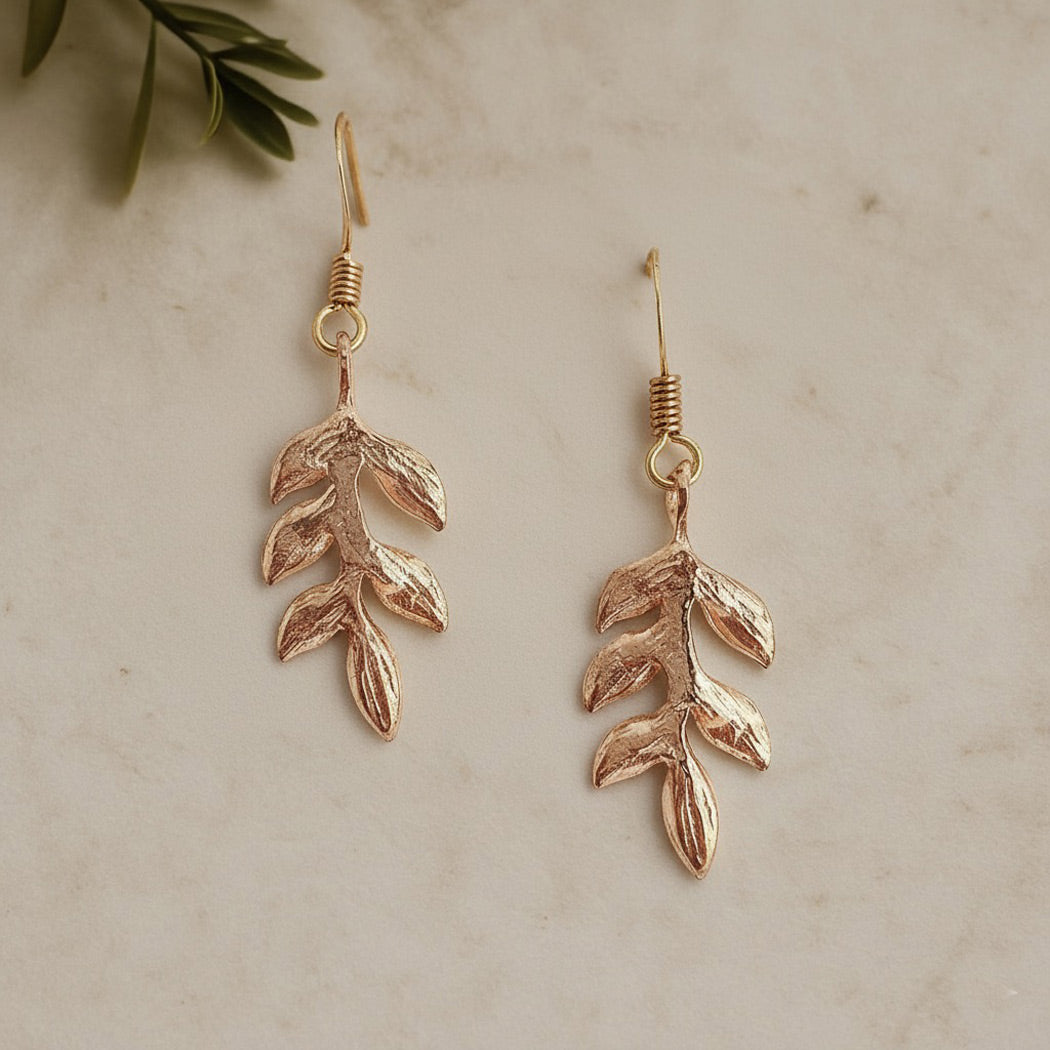 Delicate gold drop earrings with a handcrafted leaf design, perfect for brides or bridesmaids by Britten Weddings.