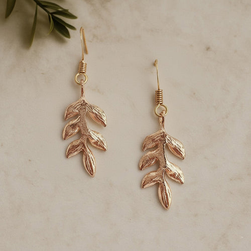 Delicate gold drop earrings with a handcrafted leaf design, perfect for brides or bridesmaids by Britten Weddings.