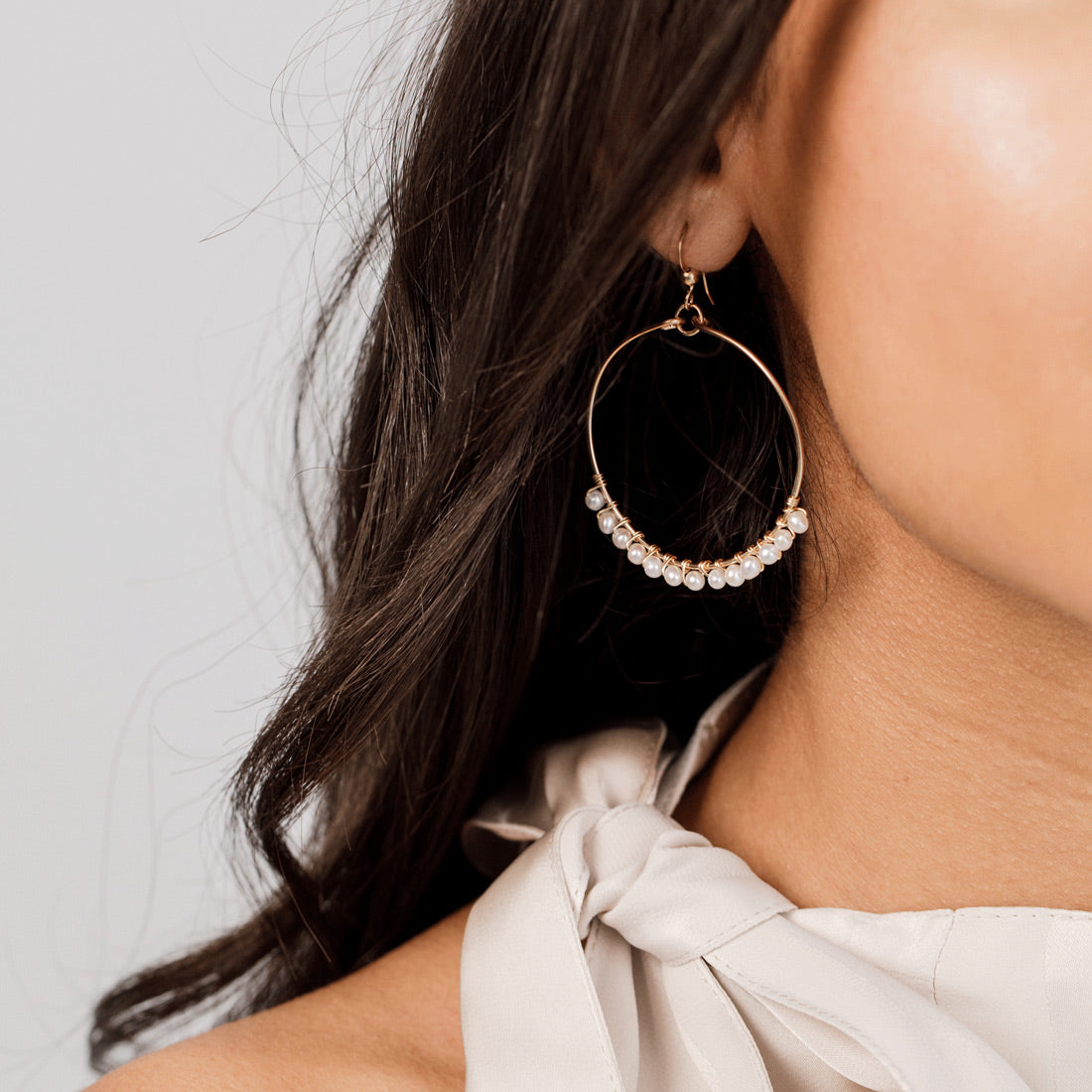 Bride wearing gold pearl hoop earrings by Britten Weddings.