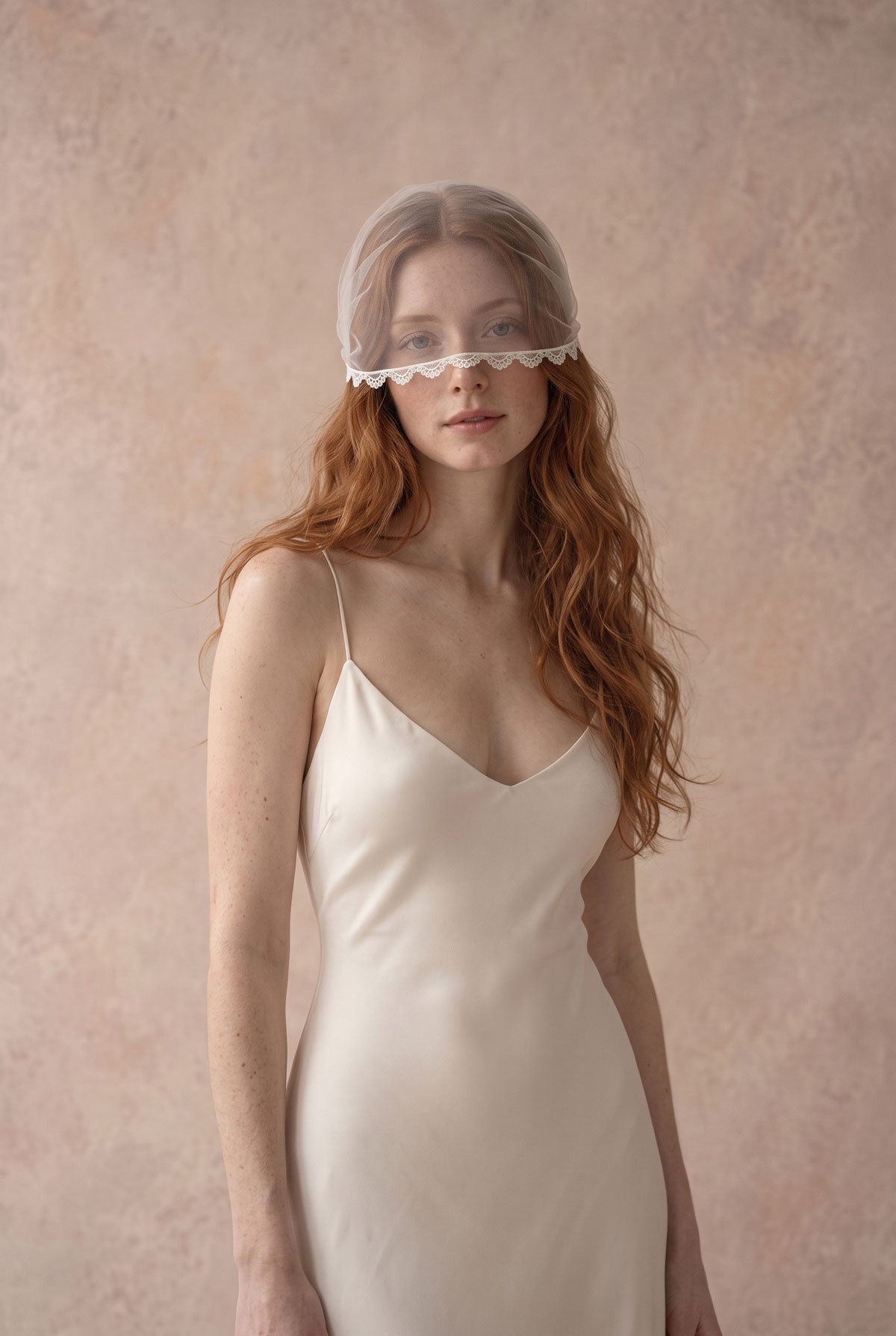 Clio lace face veil, a short tulle wedding voilette worn over the eyes