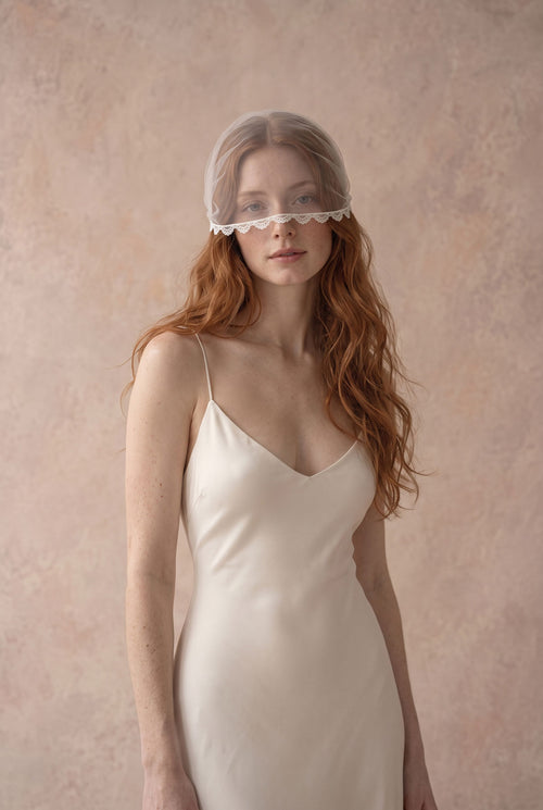 Clio lace face veil, a short tulle wedding voilette worn over the eyes
