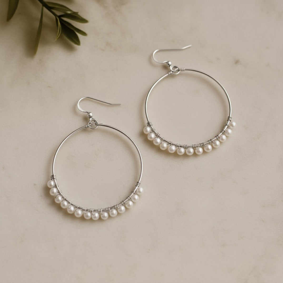 Silver hoop earrings adorned with delicate freshwater pearls, elegant handmade bridal jewellery by Britten Weddings.