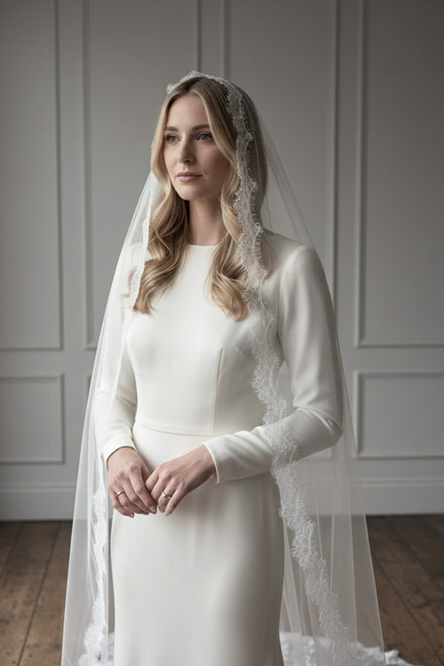 Bride wearing a Spanish-inspired mantilla veil handmade from silk-style tulle and finished with fine French eyelash lace by Britten Weddings
