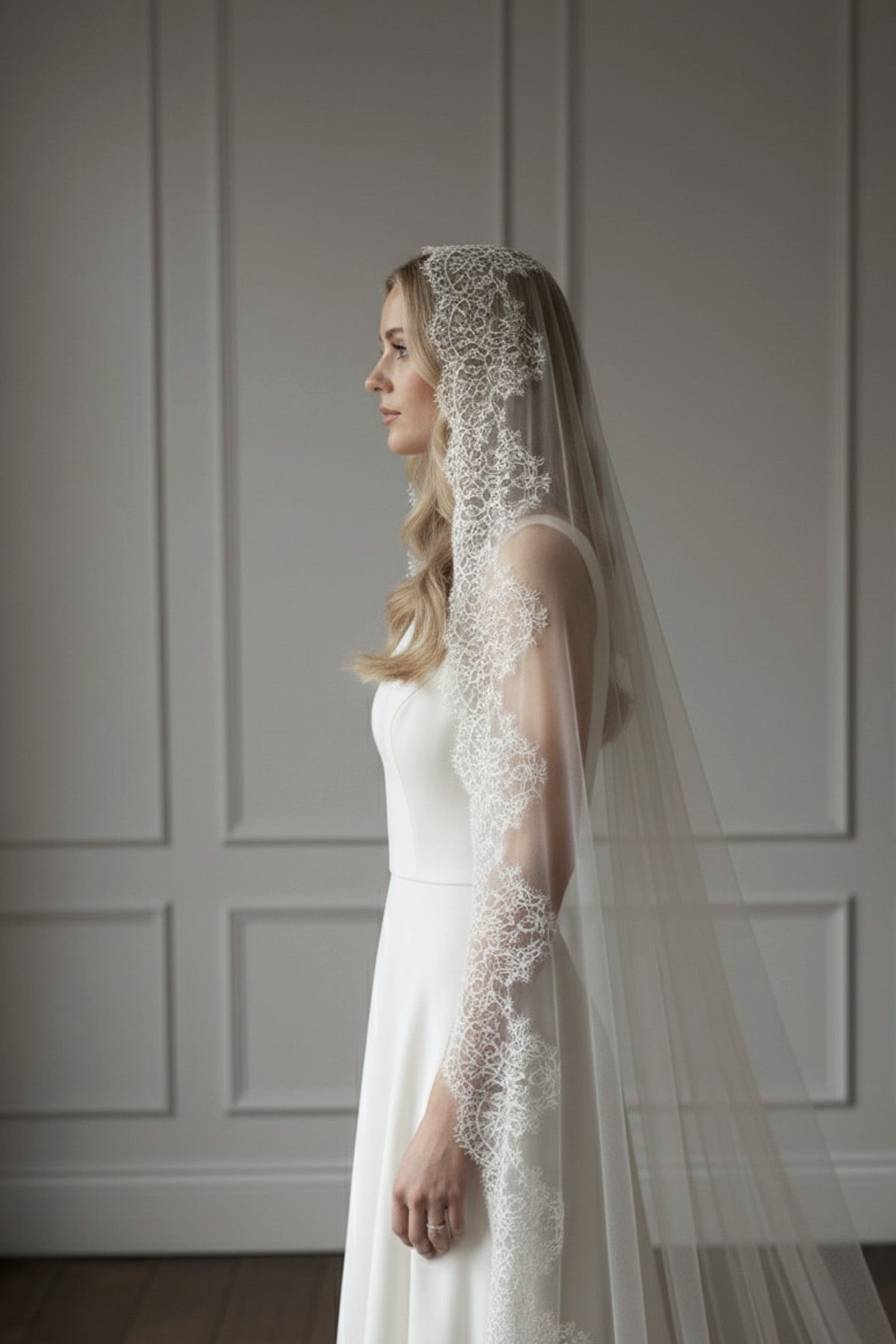 Bride in Spanish mantilla veil with wide French eyelash lace, side profile in silk-style tulle