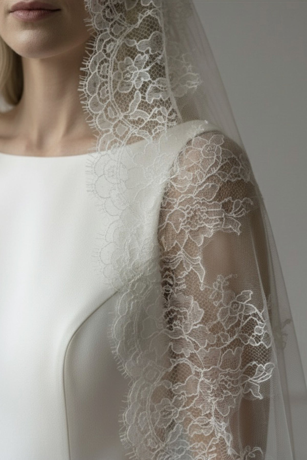 Bride wearing a mantilla wedding veil with wide scalloped French lace edging over soft silk-style tulle
